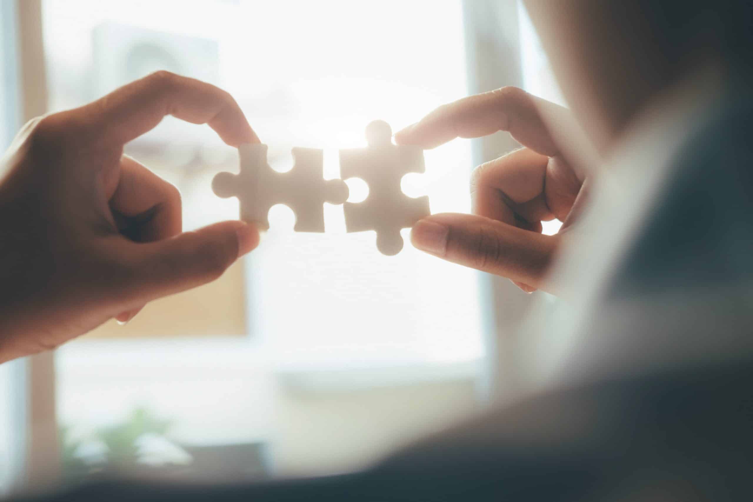 Businessman hand connecting jigsaw puzzle. Business solutions, success and strategy concept.